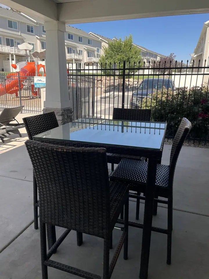 A clean covered patio with an outdoor table and chairs